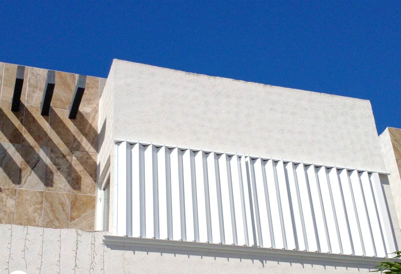 Cortinas anticiclónicas blancas instaladas en una ventana